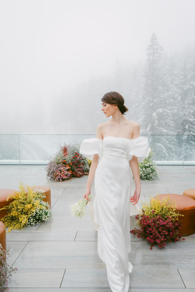 Mariée en robe de mariée satin structurée avec manches sculpturales, shooting hivernal de luxe à Six Senses Crans-Montana